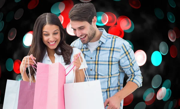 Imagen compuesta de pareja feliz con bolsas de compras — Foto de Stock