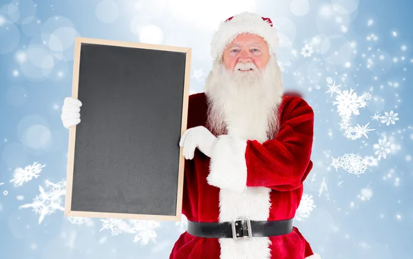 Composite image of santa claus showing blackboard — Stock Photo, Image