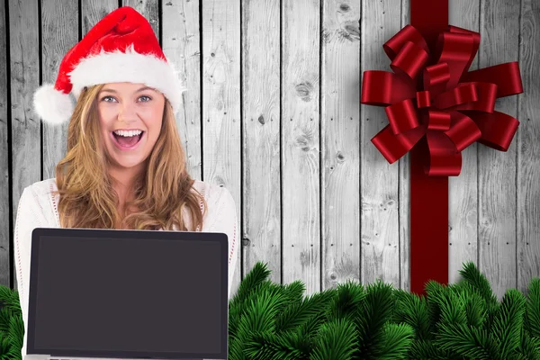 Composite image of festive blonde showing a laptop — Stock Photo, Image