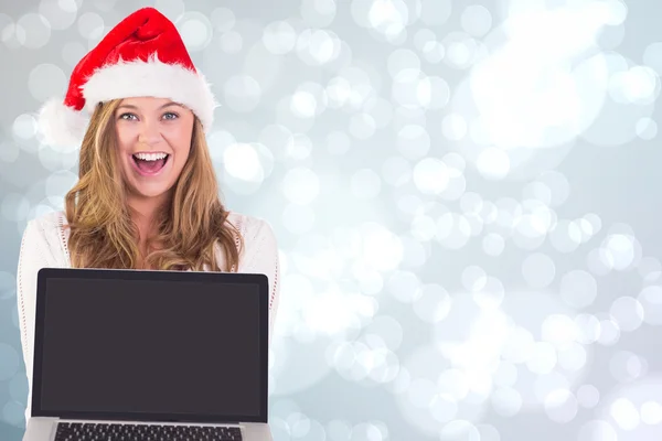 Sammansatt bild av festliga blondin visar en laptop — Stockfoto
