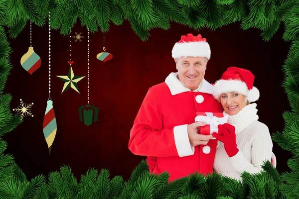 Festive mature couple holding gift — Stock Photo, Image