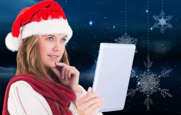 Composite image of festive blonde looking at tablet pc — Stock Photo, Image