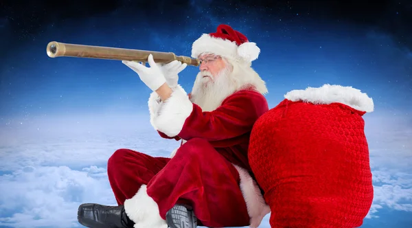 Santa claus tittar genom teleskop — Stockfoto