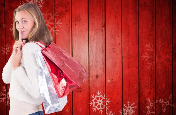 Pretty blonde keeping a secret holding bags — Stock Photo, Image