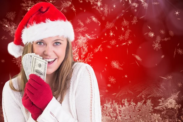 Composite image of festive blonde showing fan of dollars — Stock Photo, Image