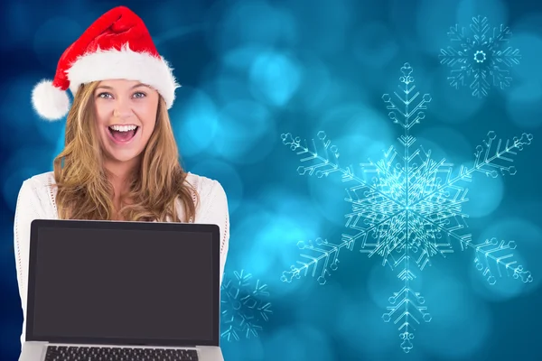 Composite image of festive blonde showing a laptop — Stock Photo, Image