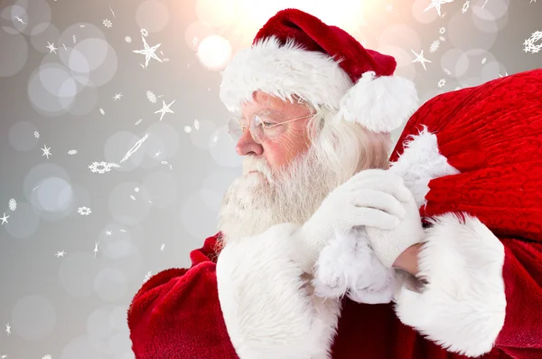 Imagen compuesta de santa claus llevando saco — Foto de Stock