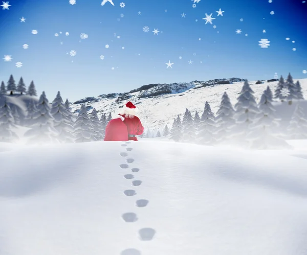 Composite image of santa walking in the snow — Stock Photo, Image