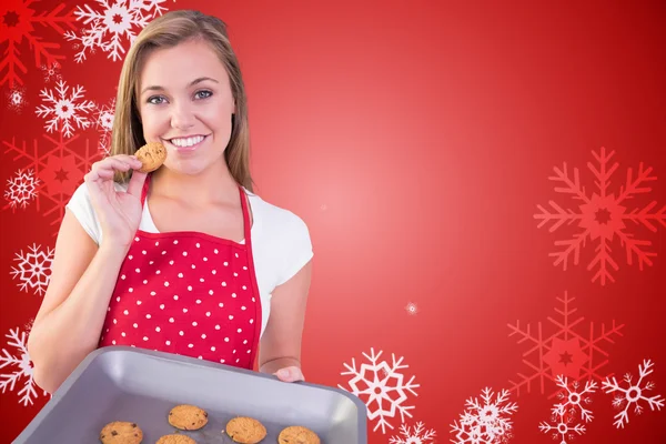 Bonita ama de casa mostrando galletas calientes — Foto de Stock