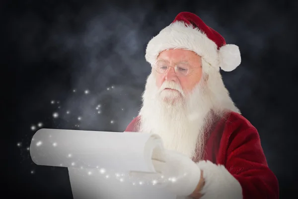 Sammansatta bilden av santa claus kontrollerat hans lista — Stockfoto