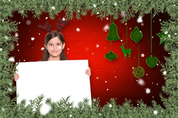 Composite image of festive little girl showing card — Stock Photo, Image