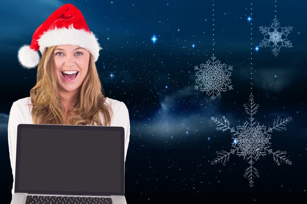 Composite image of festive blonde showing a laptop — Stock Photo, Image