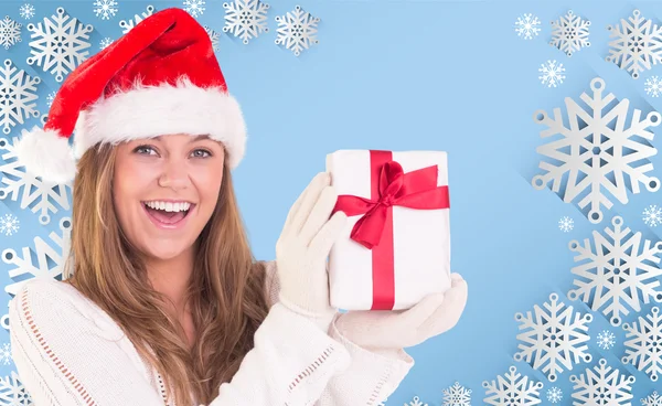 Composite image of festive blonde holding a gift — Stock Photo, Image