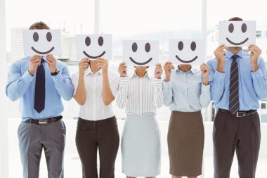 Business people holding happy smileys on faces clipart