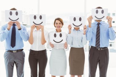 Business people holding happy smileys clipart