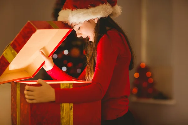 Festive little girl opening a glowing christmas gift — Stock Photo, Image