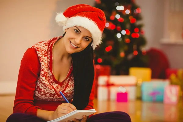 Feestelijke brunette schrijven van haar lijst — Stockfoto