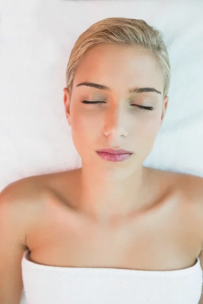 Красива жінка лежить на масажному столі — стокове фото