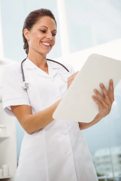 Female doctor holding clipboard in medical office — Stock Photo, Image