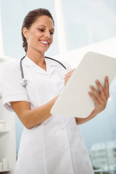 Doctora sujetando portapapeles en consultorio médico — Foto de Stock