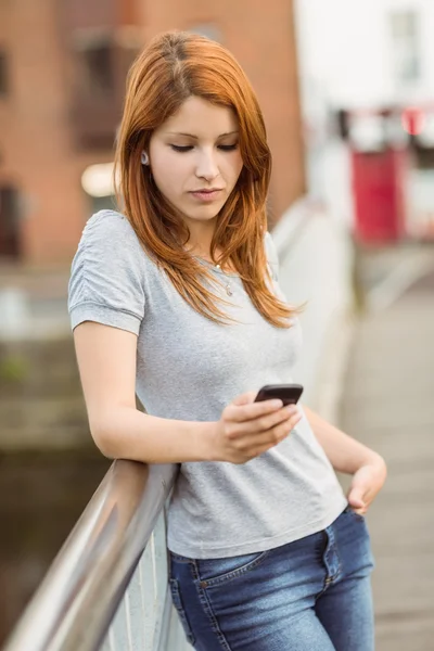 Rambut merah ceria dengan ponsel SMS-nya pesan — Stok Foto