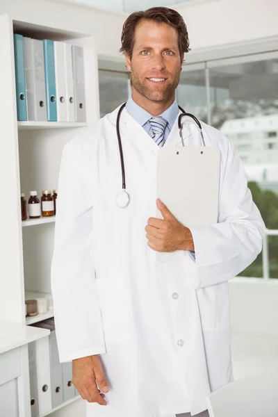 Confident doctor with reports at medical office — Stock Photo, Image