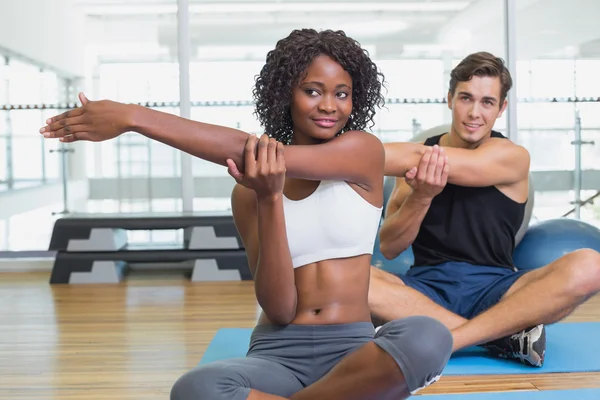Fit couple warming up on exercise mats — Stock Photo, Image