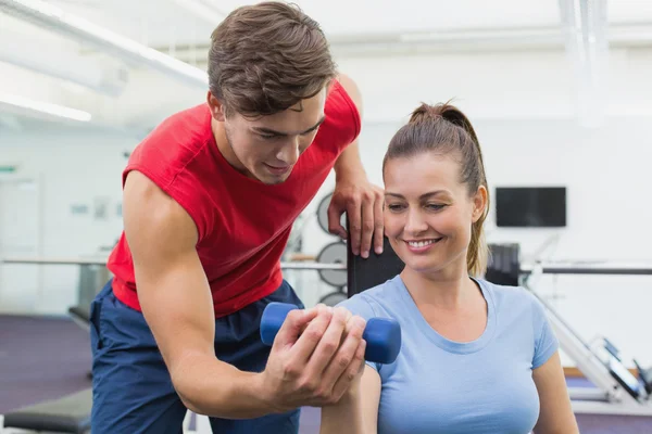 Persoonlijke trainer werken met klant houden halter — Stockfoto