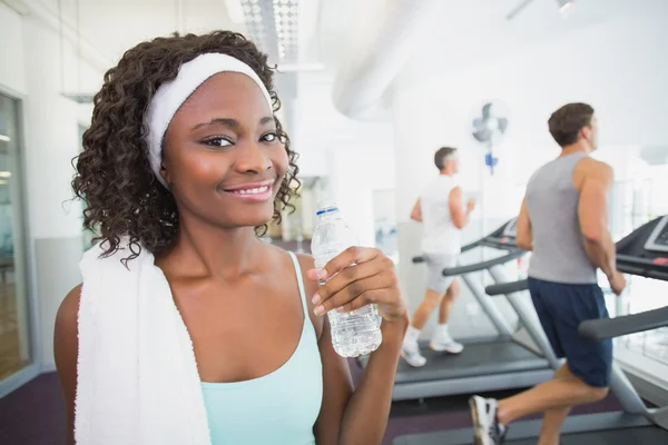 Fit mulher sorrindo para a câmera ao lado esteiras — Fotografia de Stock