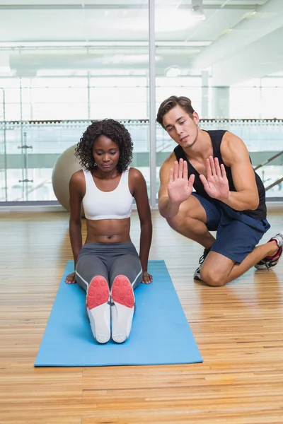 Personal trainer working with client on exercise mat — Stock Photo, Image