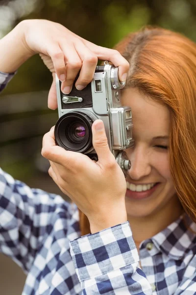 Pretty redhead taking a picture with retro camera — Stock Photo, Image