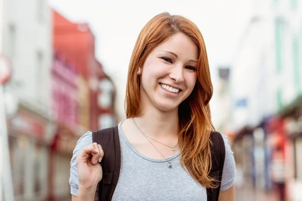 Portret van een lachende vrouw met rugzak — Stockfoto