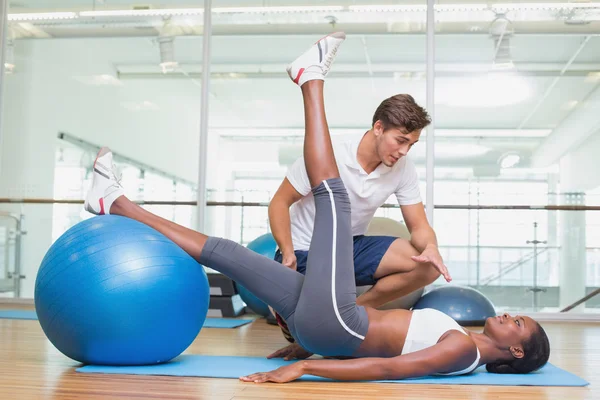 Personal trainer working with client using exercise ball — Stock Photo, Image