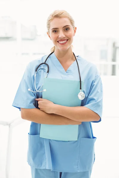 Sonriendo confiada doctora sosteniendo portapapeles — Foto de Stock