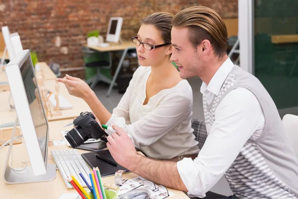 Redattori di foto sorridenti che utilizzano il computer in ufficio — Foto Stock