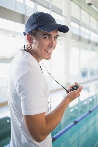 Swimming instructor holding stopwatch by the pool — Stock Photo, Image