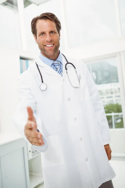 Smiling doctor offering handshake at medical office — Stock Photo, Image