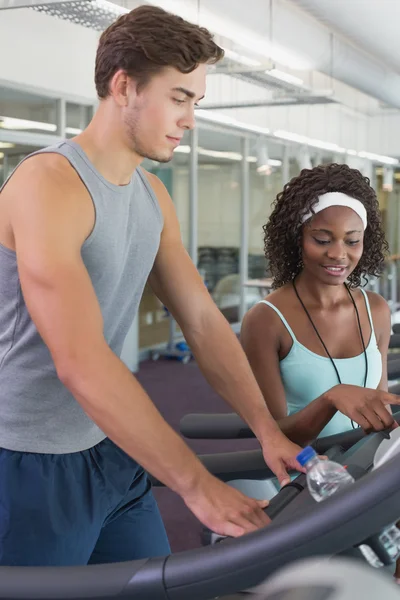 Adatto donna sul tapis roulant parlando con personal trainer — Foto Stock