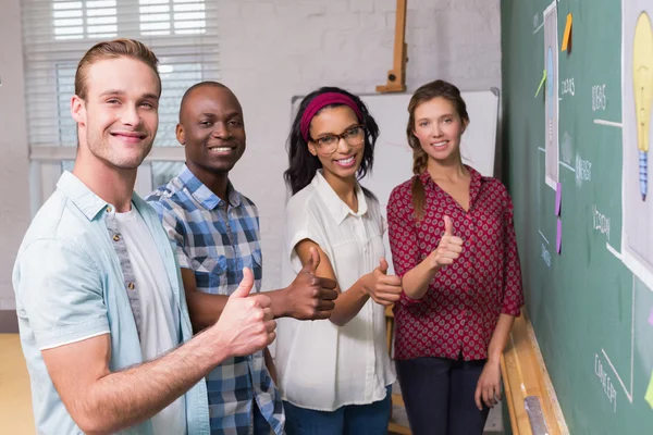 Creative business folk gestikulerande tummen upp av blackboard — Stockfoto