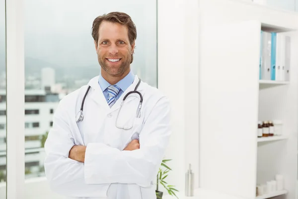 Médico varón con brazos cruzados en consultorio médico — Foto de Stock