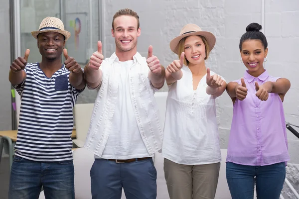 Creative colleagues gesturing thumbs up — Stock Photo, Image