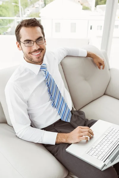 Empresário usando laptop na sala de estar — Fotografia de Stock