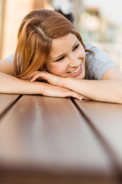 Portrait d'une rousse souriante couchée sur un banc — Photo