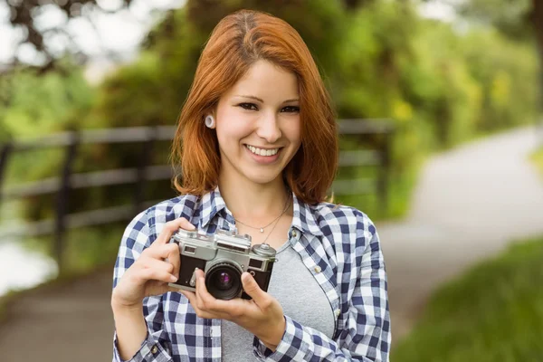 Mulher vestindo jeans e verificar camisa segurando câmera — Fotografia de Stock