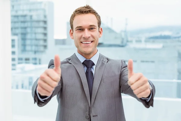 Zakenman gebaren duimschroef opwaarts in office — Stockfoto