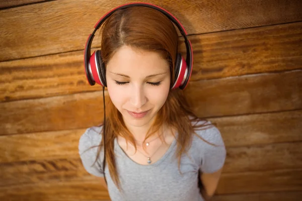 Naturliga leende rödhårig lyssna på musik med slutna ögon — Stockfoto