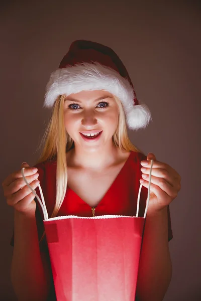 Loira festiva abrindo um saco de presente — Fotografia de Stock