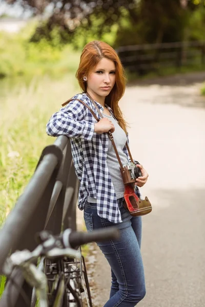 Beautiful redhead standing with bike — Stock Photo, Image