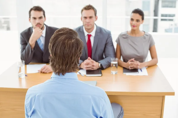 Business people interviewing man in office — Stock Photo, Image