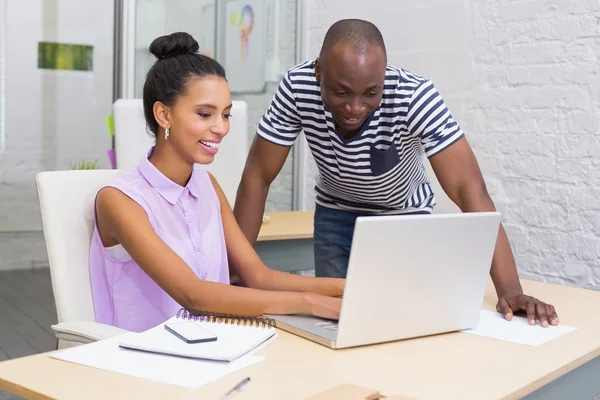 Colleghi occasionali che utilizzano il computer portatile in carica — Foto Stock